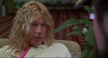 Movie still from “This Is Spinal Tap” (1984), directed by Rob Reiner – A man with blonde hair sitting in a chair; Close Up shot, Low angle