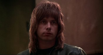 Movie still from “This Is Spinal Tap” (1984), directed by Rob Reiner – A person with long hair; Close Up shot, Low angle