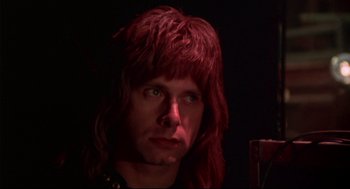 Movie still from “This Is Spinal Tap” (1984), directed by Rob Reiner – A man with red hair is looking at the camera; Close Up shot, Low angle