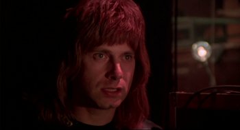 Movie still from “This Is Spinal Tap” (1984), directed by Rob Reiner – A person with long hair; Close Up shot, Low angle