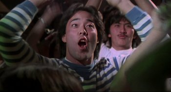 Movie still from “This Is Spinal Tap” (1984), directed by Rob Reiner – A man with his mouth wide open in a crowd of onlookers; Close Up shot, High angle