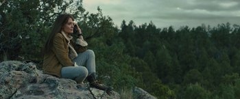 Movie still from “Those Who Wish Me Dead” (2021), directed by Taylor Sheridan – A man sitting on top of a rock on top of a hill; Medium shot, Low angle