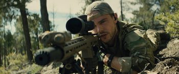 Movie still from “Those Who Wish Me Dead” (2021), directed by Taylor Sheridan – A man with a rifle aiming at something in the air; Close Up shot, Over the shoulder angle