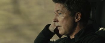 Movie still from “Those Who Wish Me Dead” (2021), directed by Taylor Sheridan – An older man is talking on a cell phone; Close Up shot, Low angle