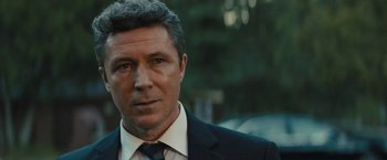 Movie still from “Those Who Wish Me Dead” (2021), directed by Taylor Sheridan – A person wearing a suit and tie; Close Up shot, Over the shoulder angle