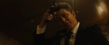 Movie still from “Those Who Wish Me Dead” (2021), directed by Taylor Sheridan – A man in a suit and tie holding a gun; Close Up shot, Over the shoulder angle