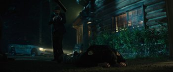 Movie still from “Those Who Wish Me Dead” (2021), directed by Taylor Sheridan – A man taking a picture of a person lying on the ground; Wide shot, Low angle