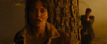 Movie still from “Those Who Wish Me Dead” (2021), directed by Taylor Sheridan – A woman in a brown jacket standing in front of a tree; Close Up shot, Low angle