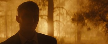 Movie still from “Those Who Wish Me Dead” (2021), directed by Taylor Sheridan – A man in a suit and tie in front of a forest; Close Up shot, Low angle
