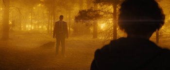 Movie still from “Those Who Wish Me Dead” (2021), directed by Taylor Sheridan – A man standing in the middle of a forest at night; Extreme Wide shot, Over the shoulder angle