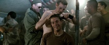 Movie still from “Three Kings” (1999), directed by David O. Russell – A man getting his hair cut by another man; Close Up shot, Over the shoulder angle