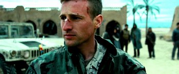 Movie still from “Three Kings” (1999), directed by David O. Russell – A person wearing a camouflage jacket; Close Up shot, Low angle