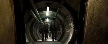 Movie still from “Three Kings” (1999), directed by David O. Russell – A group of soldiers walking down a tunnel; Wide shot, Low angle