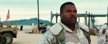 Movie still from “Three Kings” (1999), directed by David O. Russell – A man in a military uniform standing in front of a bridge; Close Up shot, Low angle