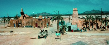 Movie still from “Three Kings” (1999), directed by David O. Russell – A desert scene with a jeep and palm trees; Extreme Wide shot, High angle