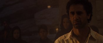 Movie still from “Three Kings” (1999), directed by David O. Russell – A man standing in front of a group of other people; Close Up shot, Over the shoulder angle