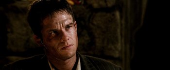 Movie still from “Three Kings” (1999), directed by David O. Russell – A person wearing a suit and tie; Close Up shot, Over the shoulder angle