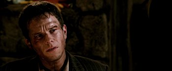 Movie still from “Three Kings” (1999), directed by David O. Russell – A person wearing a suit and tie; Close Up shot, Over the shoulder angle