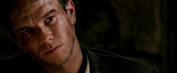 Movie still from “Three Kings” (1999), directed by David O. Russell – A person wearing a suit and tie; Close Up shot, Over the shoulder angle