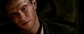 Movie still from “Three Kings” (1999), directed by David O. Russell – A person wearing a suit and tie; Close Up shot, Over the shoulder angle