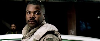 Movie still from “Three Kings” (1999), directed by David O. Russell – A man in a military uniform is looking at the camera; Close Up shot, Over the shoulder angle