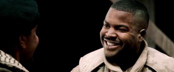 Movie still from “Three Kings” (1999), directed by David O. Russell – A person with a smile on his face; Close Up shot, Low angle