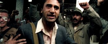 Movie still from “Three Kings” (1999), directed by David O. Russell – A person in a suit and tie; Close Up shot, Over the shoulder angle