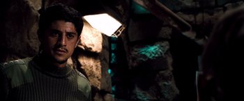 Movie still from “Three Kings” (1999), directed by David O. Russell – A man standing in front of a stone wall; Close Up shot, Low angle