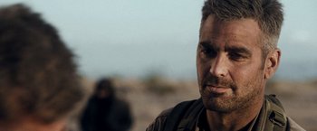 Movie still from “Three Kings” (1999), directed by David O. Russell – A person wearing a jacket; Close Up shot, Over the shoulder angle