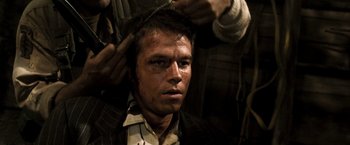 Movie still from “Three Kings” (1999), directed by David O. Russell – A young man getting his hair combed by another man; Close Up shot, Over the shoulder angle