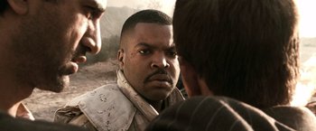 Movie still from “Three Kings” (1999), directed by David O. Russell – A man with a goatee looking into the camera; Close Up shot, Over the shoulder angle