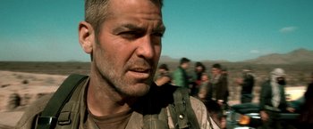 Movie still from “Three Kings” (1999), directed by David O. Russell – A person with a crowd in the background; Close Up shot, Over the shoulder angle