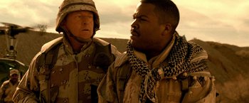 Movie still from “Three Kings” (1999), directed by David O. Russell – Two men standing next to each other on a field; Close Up shot, Over the shoulder angle