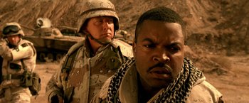 Movie still from “Three Kings” (1999), directed by David O. Russell – Two men in military fatigues standing next to each other; Close Up shot, Over the shoulder angle
