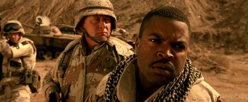 Movie still from “Three Kings” (1999), directed by David O. Russell – Two men in military fatigues are standing in the desert; Close Up shot, Low angle