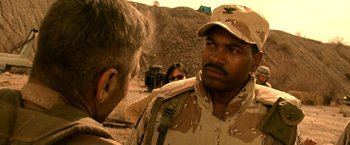 Movie still from “Three Kings” (1999), directed by David O. Russell – A man in a military uniform talking to another man in fatigues; Close Up shot, Over the shoulder angle