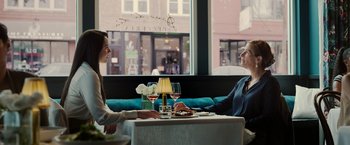 Movie still from “Ticket to Paradise” (2022), directed by Ol Parker – A man and a woman sitting at a table with wine glasses; Medium shot, Over the shoulder angle