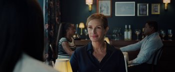 Movie still from “Ticket to Paradise” (2022), directed by Ol Parker – A woman sitting at a table in front of another woman; Close Up shot, Over the shoulder angle