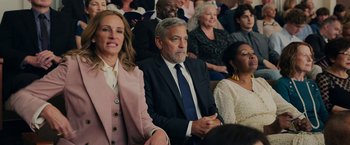 Movie still from “Ticket to Paradise” (2022), directed by Ol Parker – A group of people sitting in a room; Medium shot, Over the shoulder angle