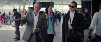 Movie still from “Ticket to Paradise” (2022), directed by Ol Parker – A group of people walking in a building; Medium shot, Over the shoulder angle