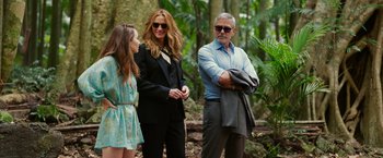 Movie still from “Ticket to Paradise” (2022), directed by Ol Parker – Two women and an older man standing next to each other in the woods; Medium shot, Over the shoulder angle