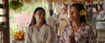 Movie still from “Ticket to Paradise” (2022), directed by Ol Parker – Two women standing next to each other in front of a crowd; Close Up shot, Over the shoulder angle