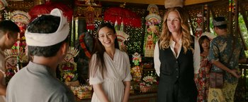 Movie still from “Ticket to Paradise” (2022), directed by Ol Parker – Two women standing next to each other in front of a display; Medium shot, Over the shoulder angle