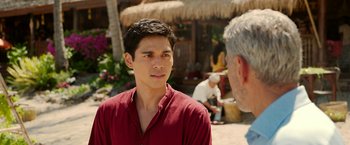Movie still from “Ticket to Paradise” (2022), directed by Ol Parker – A man in a red shirt is talking to another man in a red shirt; Close Up shot, Over the shoulder angle