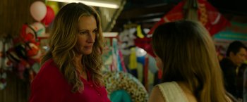 Movie still from “Ticket to Paradise” (2022), directed by Ol Parker – A woman talking to another woman in a booth; Close Up shot, Over the shoulder angle