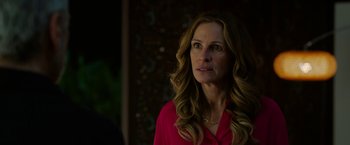 Movie still from “Ticket to Paradise” (2022), directed by Ol Parker – A woman in a red shirt is looking at the camera; Close Up shot, Over the shoulder angle