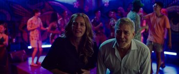 Movie still from “Ticket to Paradise” (2022), directed by Ol Parker – A man and a woman standing next to each other; Medium shot, Over the shoulder angle