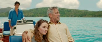 Movie still from “Ticket to Paradise” (2022), directed by Ol Parker – A man and a woman sitting next to each other on a boat in the water; Medium shot, Over the shoulder angle