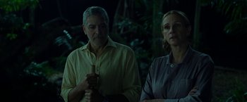Movie still from “Ticket to Paradise” (2022), directed by Ol Parker – A man and a woman standing next to each other in front of trees; Medium shot, Over the shoulder angle
