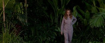 Movie still from “Ticket to Paradise” (2022), directed by Ol Parker – A woman standing in front of some plants; Wide shot, High angle